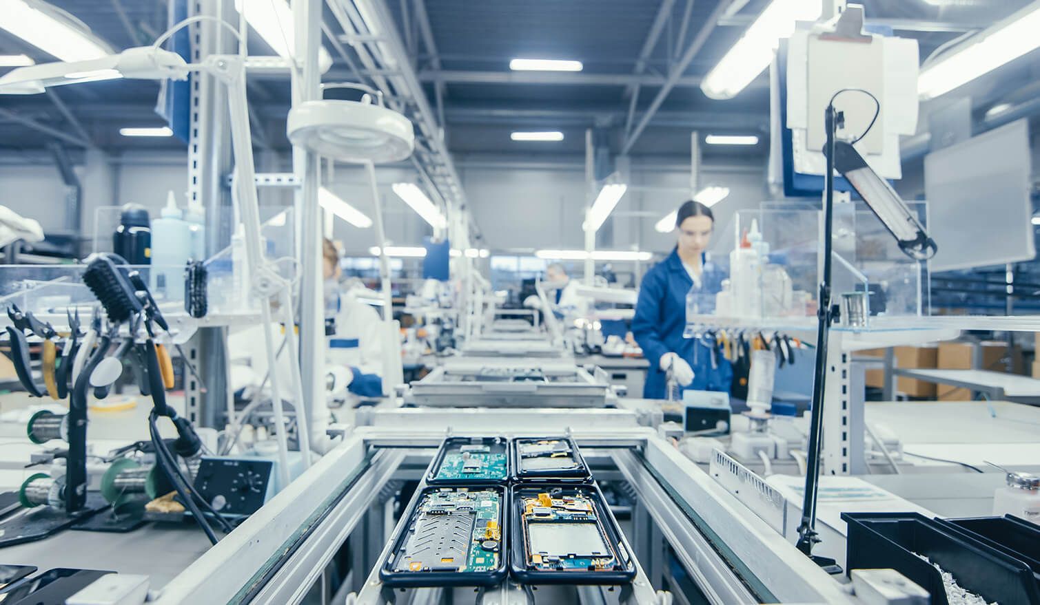 Zaměstnanci ve výrobním závodě montují elektronické součástky v odpovídajícím osvětlení