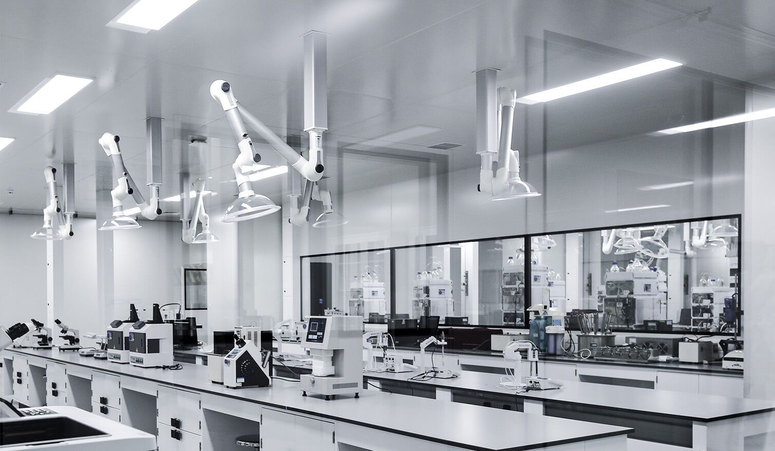 Laboratoř s bílými stěnami, moderním vybavením a osvětlením, vytvořená pro farmaceutický průmysl
