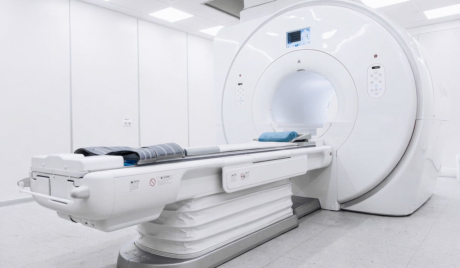 Bílá místnost s přístrojem MRI, ve které byla použita lampa Lumedic, vytvářející klidné a funkční osvětlení